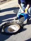 Pouring mixed FloMix into a pothole